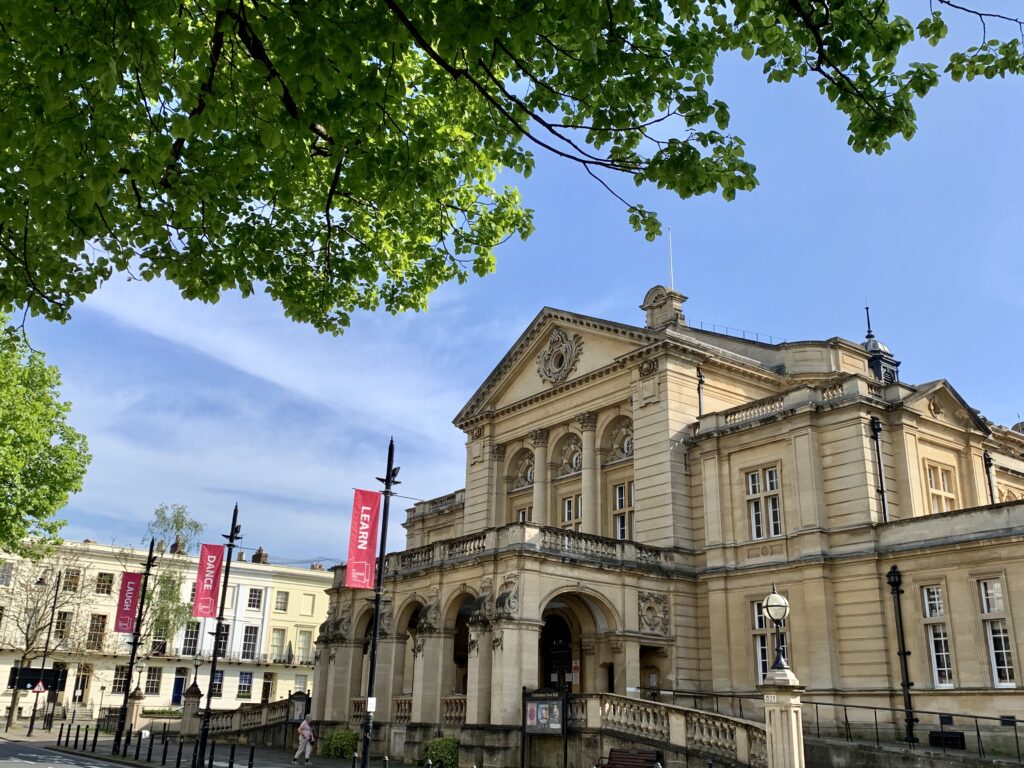 Cheltenham Town Hall picture taken by Visit Cheltenham. Blue Sky. Regency building. Trees.