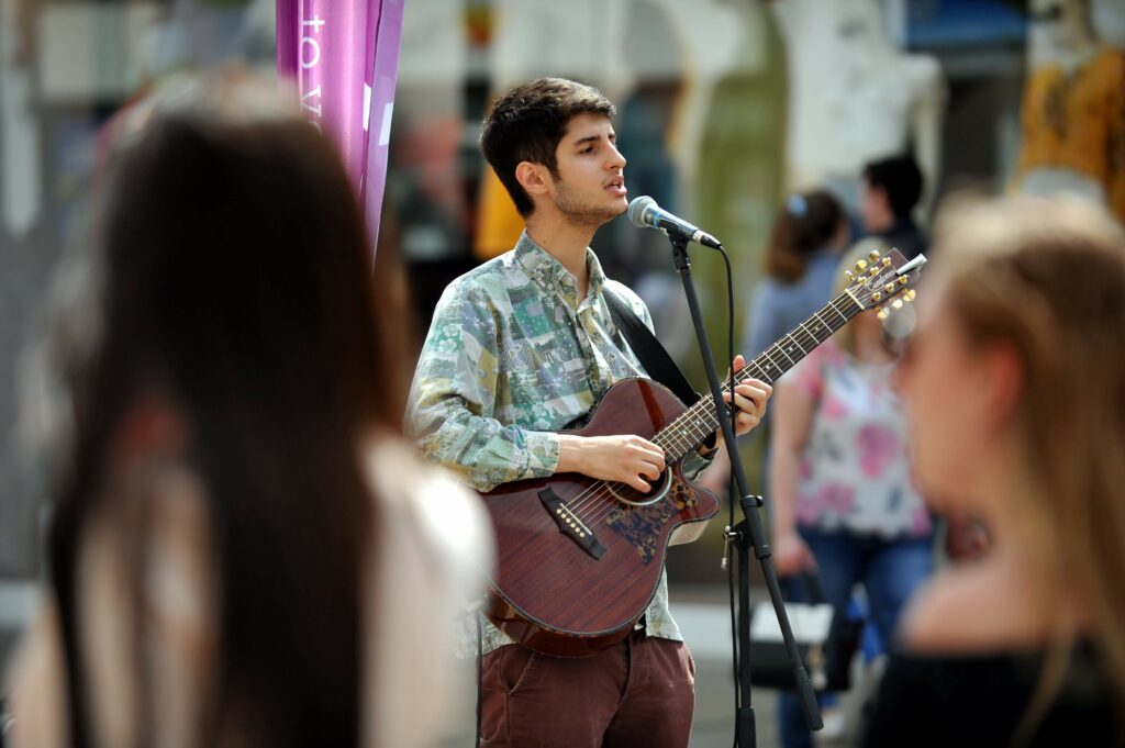 A singer performing on Cheltenham high street for Cheltenham music festival